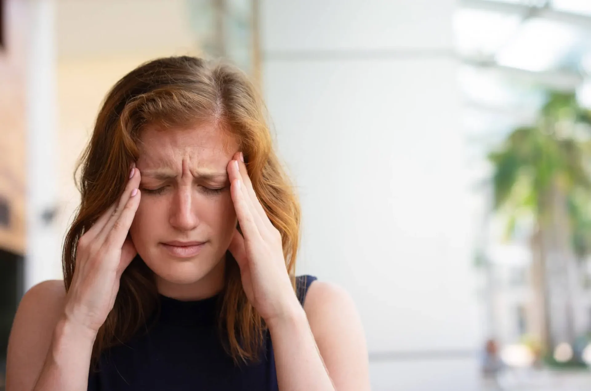 woman with headache sitting at the table